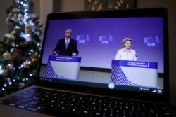 European Union's chief Brexit negotiator Michel Barnier and European Commission President Ursula von der Leyen are seen on a computer screen while giving live a statement on the outcome of the Brexit negotiations, in Brussels, Belgium, Dec. 24, 2020.