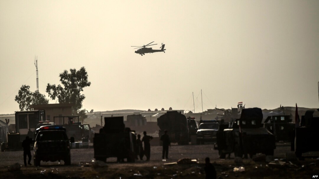 FILE - A helicopter prowls the perimeter of the Qayyarah military base, south of Mosul, Oct. 18, 2016.