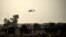 FILE - A helicopter prowls the perimeter of the Qayyarah military base, south of Mosul, Oct. 18, 2016.