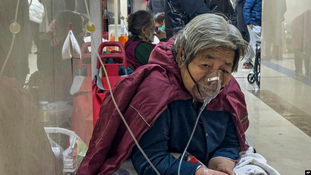 资料照片：2023年1月5日，一名老年患者在北京急诊病房走廊带着呼吸机接受静脉滴注。(美联社照片)