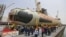 Employees stand near the Indian Navy's first Scorpene submarine before being undocked on April 6 at a naval vessel ship building yard in Mumbai.