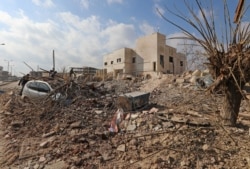 FILE - Destruction is seen around the Udai hospital following airstrikes on the town of Saraqeb in Syria's northwestern province of Idlib, Jan. 29, 2018.