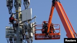 Para pekerja memasang peralatan jaringan 5G untuk perusahaan telekomunikasi Verizon di kota Orem, Utah, AS (foto: dok). 