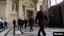 FILE - Police patrol inside the Paris courthouse.