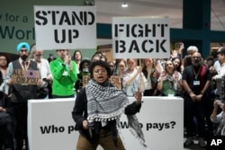 Aktivis Gina Marcela Cortes Valderrama, tengah, turut serta dalam aksi demonstrasi menuntut pendanaan iklim di COP29, Baku, Azerbaijan, 23 November 2024. (Foto: AP)