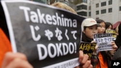 FILE - South Korean high school students stage a rally against Japan's Takeshima Day in front of the Japanese Embassy in Seoul, South Korea, Feb. 22, 2017.