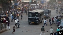 Indians throw stones on police vehicles during a protest against the Citizenship Amendment Act and the National Register of Citizens in Ahmadabad, India, Dec. 19, 2019. 