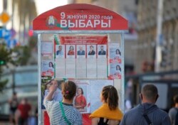 People look at a presidential election information board in Minsk, Belarus, Aug. 7, 2020.