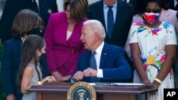 President Joe Biden talks with Logan Evans and Abigail Evans, children of USCP Officer William "Billy" Evans, before signing a bill in the Rose Garden of the White House, Aug. 5, 2021.