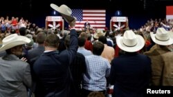 FILE - Supporters listen to President Donald Trump speak during an event at Loren Cook Company in Springfield, Missouri, Aug. 30, 2017.