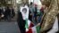 FILE - A demonstrator holds a portrait of the Iranian Supreme Leader Ayatollah Ali Khamenei as a girl holds the country's national flag in a rally in front of the former U.S. Embassy commemorating the anniversary of its 1979 seizure in Tehran, Iran, Nov. 
