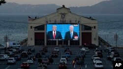 Los candidatos presidenciales a las elecciones 2020, el republicano Donald Trump y el demócrata Joe Biden, en el debate del pasado 22 de octubre, vistos en una pantalla gigante en San Francisco, California.