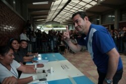 Guatemalan President Jimmy Morales shows his ink-stained finger after casting his ballot at a polling station during the presidential election second round run-off vote in Mixco, Guatemala, Aug. 11, 2019.