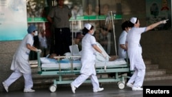 Medical personnel transport a victim of a factory explosion, at a hospital in Kunshan, Jiangsu province, August 2, 2014. An explosion killed at least 65 people and injured more than 120 at a factory in China that makes wheels for U.S. carmakers, including