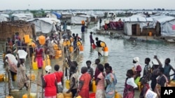 FILE —Displaced South Sudanese women queue in knee-deep floodwaters to access fresh water from a borehole via a tap, at a makeshift camp for the displaced in the United Nations Mission in South Sudan (UNMISS) base Bentiu, South Sudan September 22, 2014.