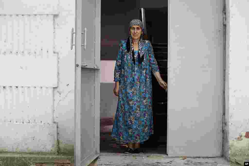 A woman stands in her entryway in downtown Dushanbe. (VOA - Y. Weeks)