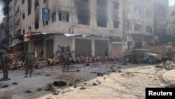 Captured and detained Palestinians sit on a street in Beit Lahia