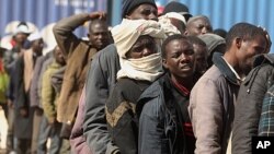 Migrant workers from Africa stand in a line after they arrive by ship from Misrata during an evacuation operation organized by the International Organization for Migration (IOM) at the port of Benghazi May 5, 2011. REUTERS/Mohammed Salem