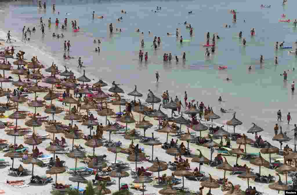 Tourists crowd Palma de Mallorca&#39;s Arenal beach on the Spanish Balearic island of Mallorca. Spain was host to 28 million foreign tourists in the first half of 2014, a 7.3 percent increase over the same period in 2013, according to figures from the Spanish Institute for Tourist Studies.