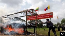 Seorang polisi Myanmar menyulutkan api ke tumpukan narkoba yang berhasil disita dan dimusnahkan pada acara Anti Penyelundupan Obat-obatan Sedunia, 26/6/2013. 