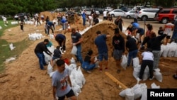 Un grupo de personas llena sacos de arena como preparación para la llegada del huracán Milton en Orlando, Florida, el 8 de octubre de 2024.