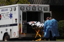 In Hammonton, New Jersey, EMTs load a patient into an ambulance outside of the Hammonton Center for Rehabilitation and Healthcare one of numerous nursing homes to have staffing shortages, May 19, 2020.