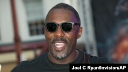 FILE - Actor Idris Elba poses for photographers at a special screening of Fast & Furious: Hobbs & Shaw, in a central London cinema, July 23, 2019. Elba has tested positive for the coronavirus. 