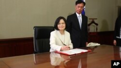 Taiwan's President Tsai Ing-wen signs her first document at her new desk following the inauguration ceremony at the Presidential Office in Taipei, Taiwan May 20, 2016. 