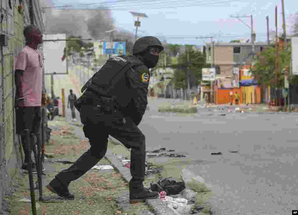 Un policía se alista a intervenir durante un tiroteo entre pandillas y policías en Puerto Príncipe.&nbsp;