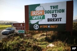 FILE - A car passes a Brexit sign on the old Belfast to Dublin road, close to the Irish border in Newry, Northern Ireland, Oct. 16, 2019.