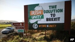 FILE - A car passes a Brexit sign on the old Belfast to Dublin road, close to the Irish border in Newry, Northern Ireland, Oct. 16, 2019.