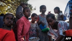 Displaced children from Western Tigray gather at meal time to receive food outside a classroom in the school where they are sheltering in Tigray's capital Mekele, Ethiopia, Feb. 24, 2021.