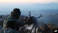 Syrian army personnel, backed by Russian airstrikes, fires machine gun in Latakia province, near border with Turkey, Oct. 10, 2015.