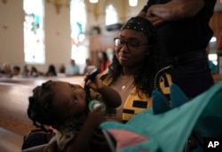 La feligresa Rose Carmelle Bellevue mira a su hijo de un año durante un servicio en la iglesia católica St. Raphael en Springfield, Ohio, el domingo 15 de septiembre de 2024.