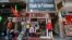 FILE - Vendors sit outside a shop selling clothes in Hanoi, Oct. 3, 2014.