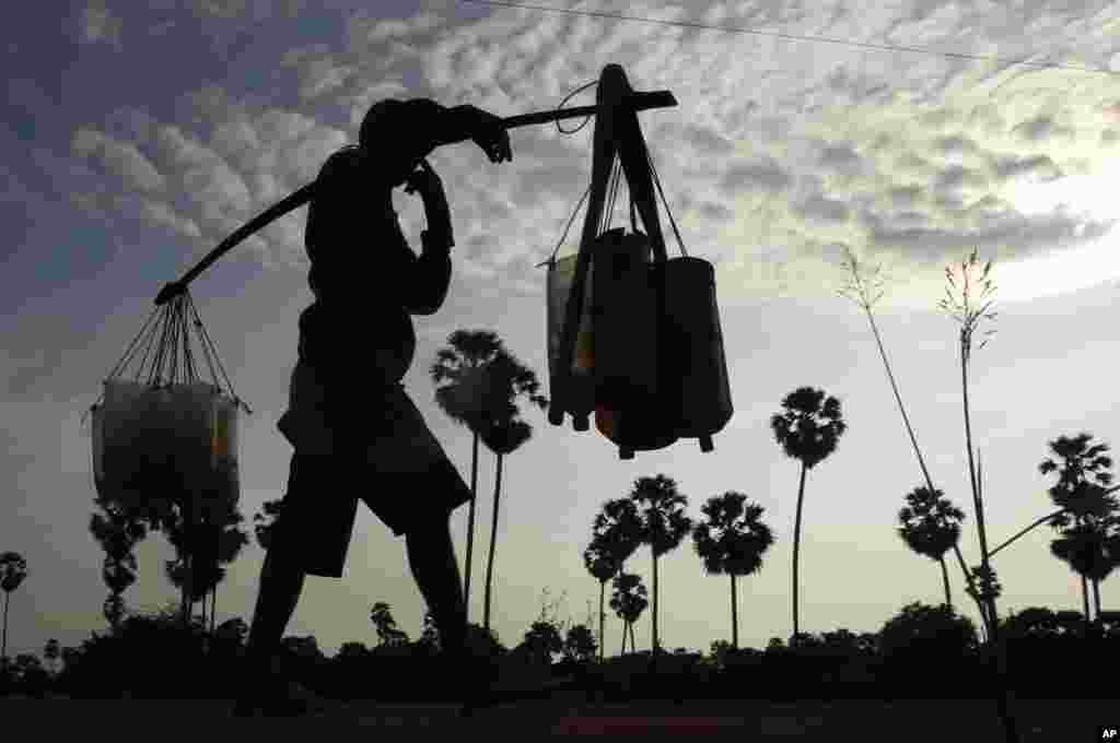 A man carrying plastic tubes full of palm juice at the Samroang village on the north side of Phnom Penh, Cambodia.