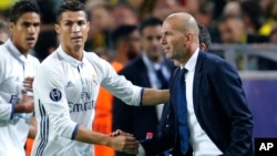 Cristiano Ronaldo de Real Madrid salue l'entraîneur de son équipe, Zinedine Zidane, après avoir ouvert le score lors d’un match de football de la Champions League entre le Borussia Dortmund et le Real Madrid à Dortmund, Allemagne, 27 septembre 2016. 