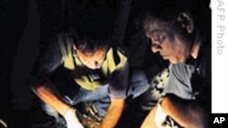 Bangladeshi bomb squad police officers collect evidence at scene of Dhaka bomb blast, 21 Oct 2009