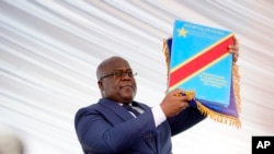 FILE - Congolese President Felix Tshisekedi holds the constitution after being sworn in in Kinshasa, Democratic Republic of the Congo, Jan. 24, 2019.