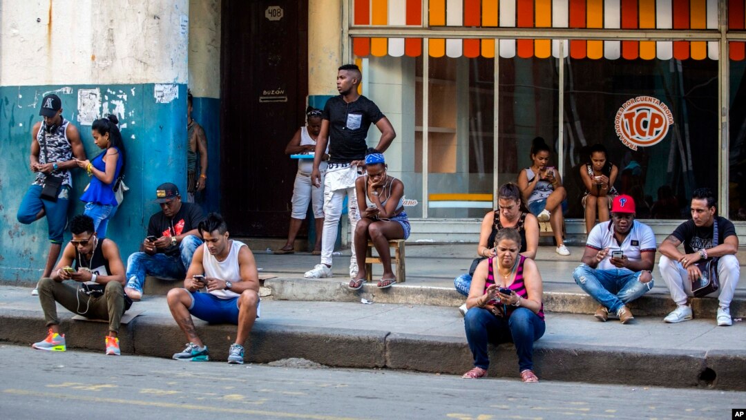 Warga Kuba berusaha mengakses internet dengan ponselnya, di sebuah fasilitas wifi yang tersedia untuk umum di Havana (foto: ilustrasi). 