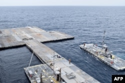FILE - In this photo provided by the U.S. Central Command and taken on April 26, 2024, construction work continues on the floating pier in the Mediterranean Sea.