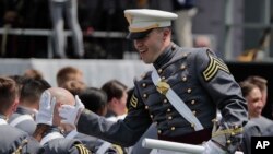 A West Point cadet gets a high five from a friend after receiving his diploma during graduation ceremonies at the United States Military Academy, Saturday, May 26, 2018, in West Point, N.Y.