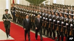 中国国家主席胡锦涛1月9日在北京人大会堂欢迎到访的韩国总统李明博(中右)