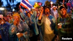 Anti-government protesters wear colorful rain coats as they block the road outside the Interior Ministry in Bangkok, Nov. 26, 2013.