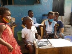 Dora Oppey, not pictured, gets her and her neighbors' kids to participate in the radio reading program, in Accra, Ghana, Aug. 13, 2020. (Stacey Knott/VOA)