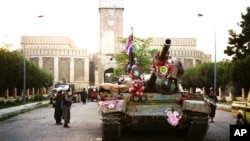 FILE - In this Sept. 28, 1996, photo, tanks manned by Taliban fighters and decorated with flowers are seen in front of the the presidential palace in Kabul, Afghanistan. 