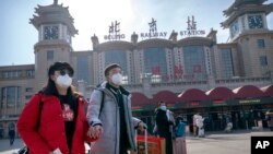 춘절 연휴를 앞둔 중국인들이 10일 신종 코로나바이러스 예방 마스크를 쓰고 베이징 기차역에서 이동하고 있다. 