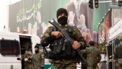 Members of the police stand guard on a street, with a large billboard featuring Iran's late Supreme Leader Ayatollah Ali Khamenei in the background, in Tehran (Reuters)