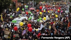 Para pengunjuk rasa berpawai dalam aksi mogok nasional memprotes rencana pemerintah menaikkan pajak, di Bogota, Kolombia, Rabu, 28 April 2021. (Foto: Fernando Vergara/AP)