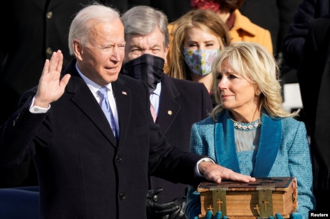 FILE - Joe Biden is sworn in as the 46th president of the United States by Chief Justice John Roberts as Jill Biden holds the Bible during the 59th Presidential Inauguration at the U.S. Capitol in Washington, U.S., January 20, 2021. (Andrew Harnik/Pool/REUTERS)